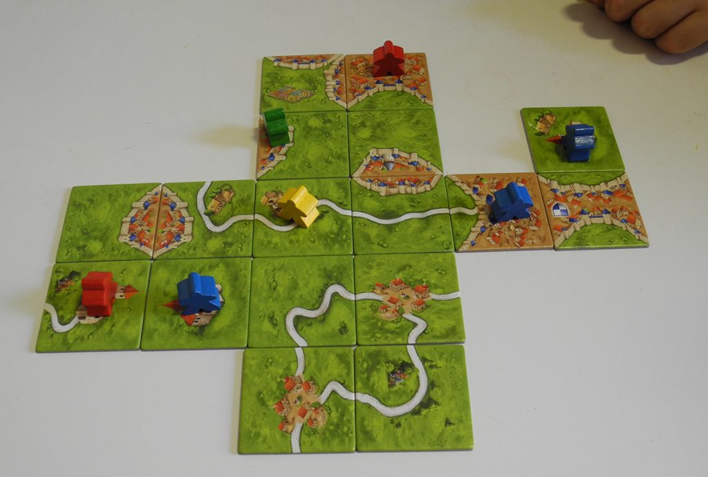 Un inizio di partita a Carcassonne, con tessere paesaggio già disposte e pedine giocate