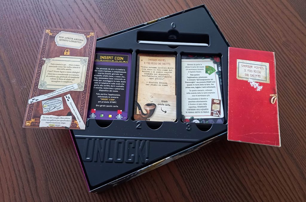 Escape Room da tavolo - la scatola di un Unlock aperta con le prime carte delle tre avventure