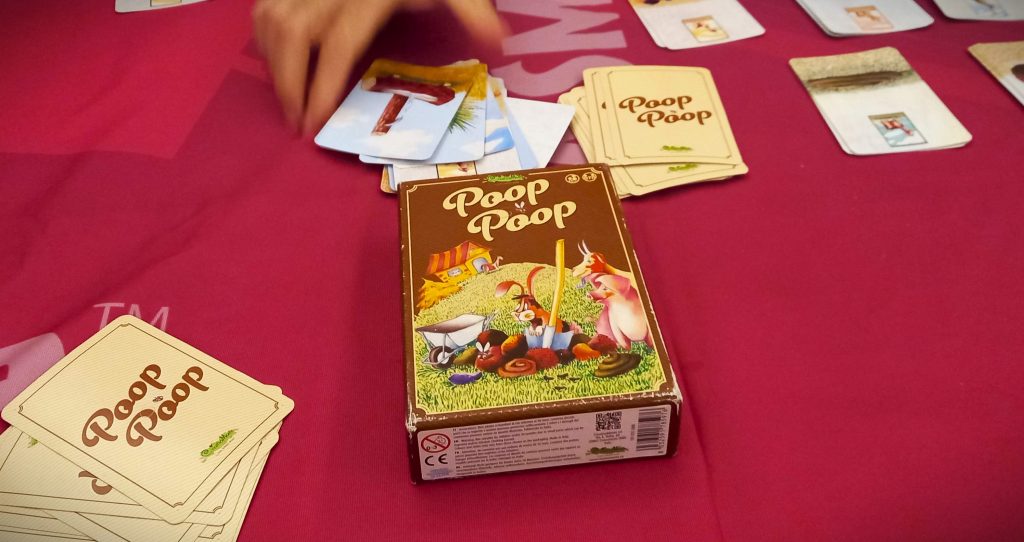 Scatola e carte di Poop Poop, un gioco di CreativaMente provato a Lucca Comics and Games
