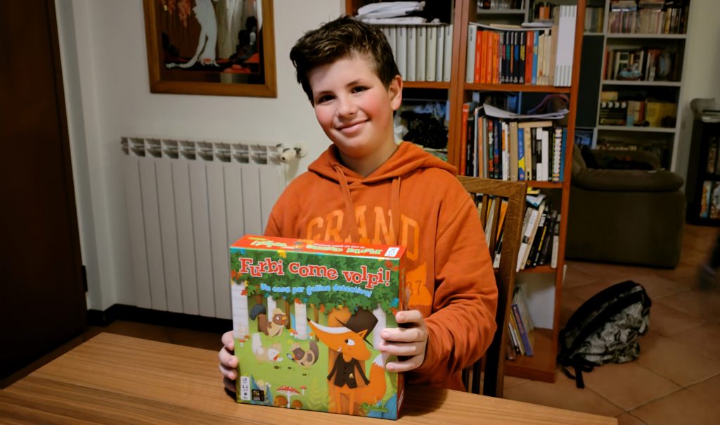 Lorenzo con la scatola del gioco "Furbi come Volpi"