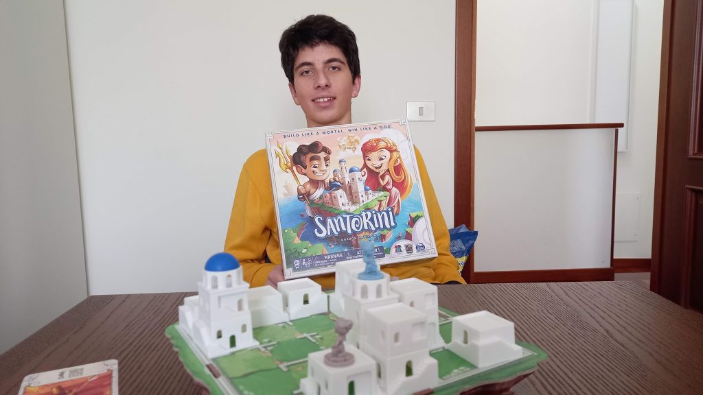 Davide con la scatola del gioco "Santorini"